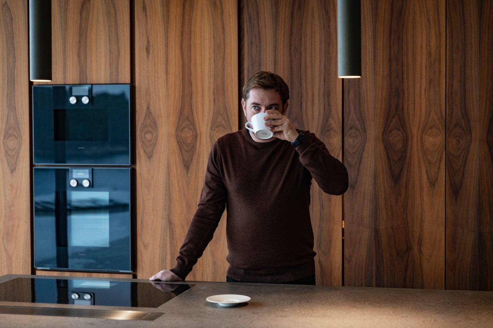 Man drinking coffee in kitchen